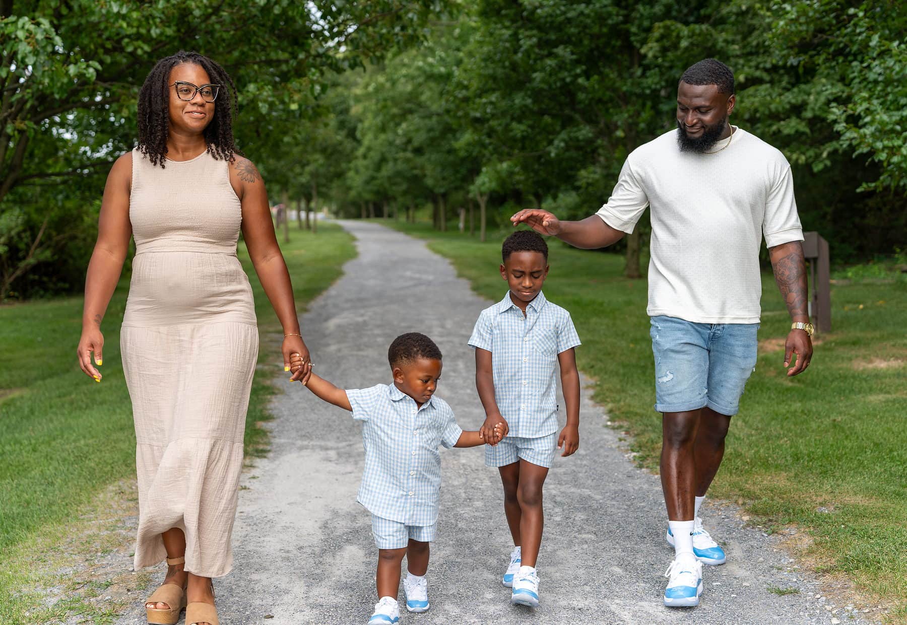 A family of four walking a tree lined path together at Rocky Ridge County Park