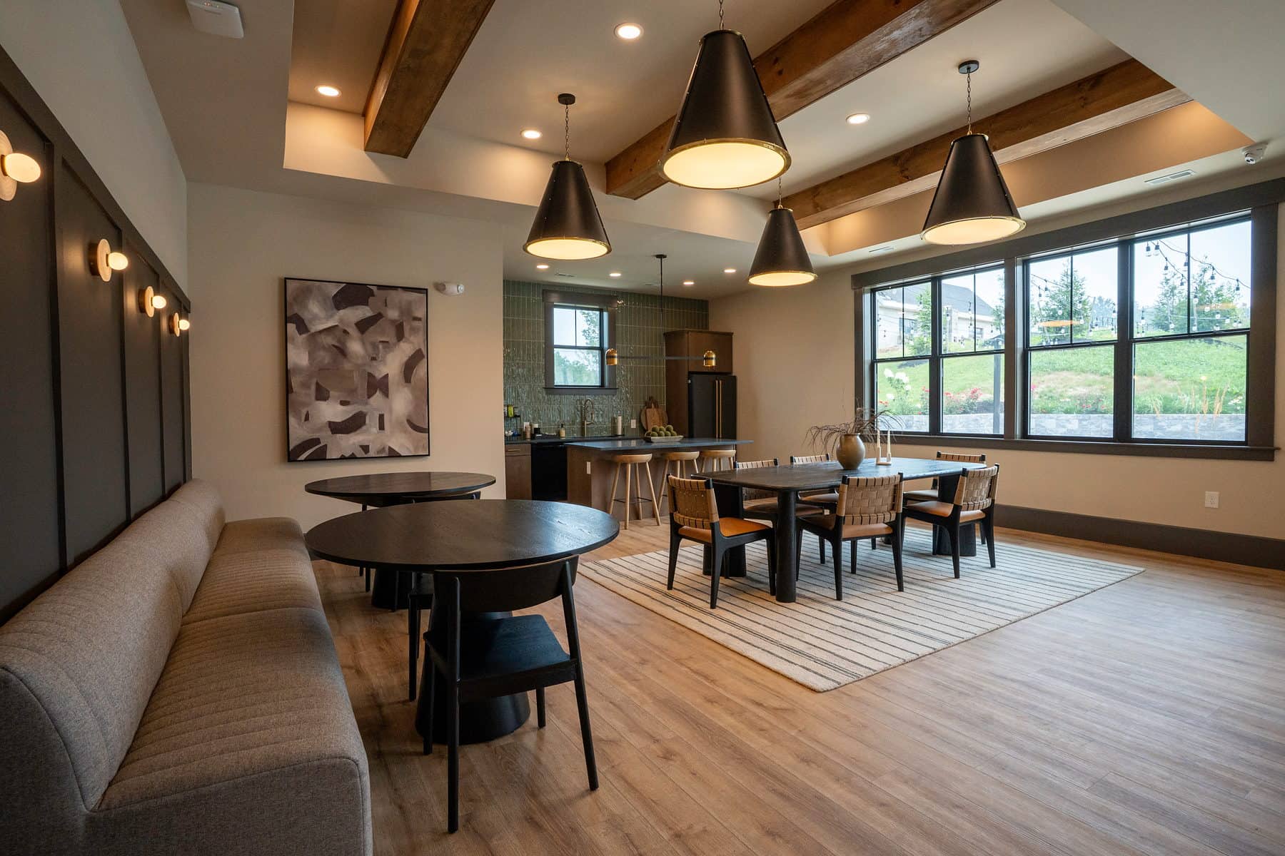 A clubhouse dining area with banquette seating and a bar beyond