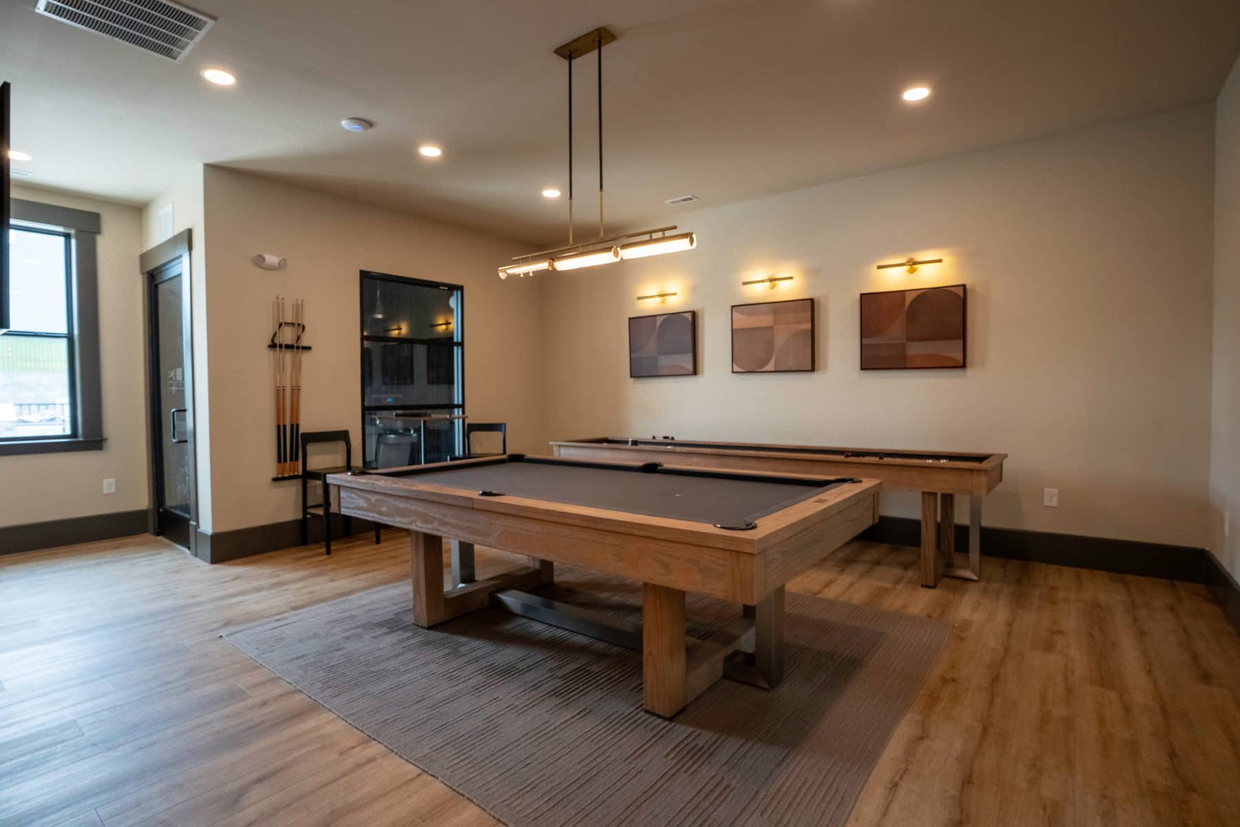 A community game room with a full size pool table and framed art