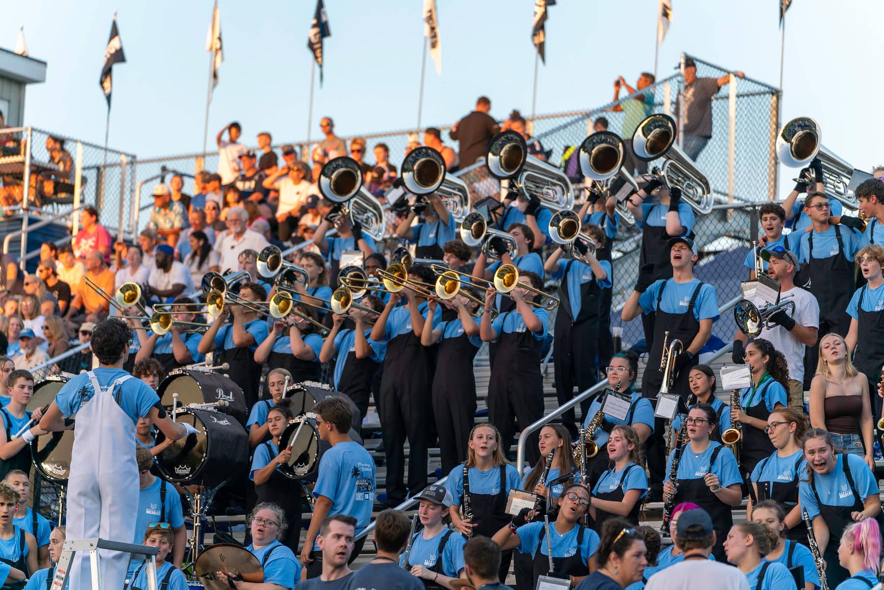 A high school pep band playing in the stands during a Friday night game