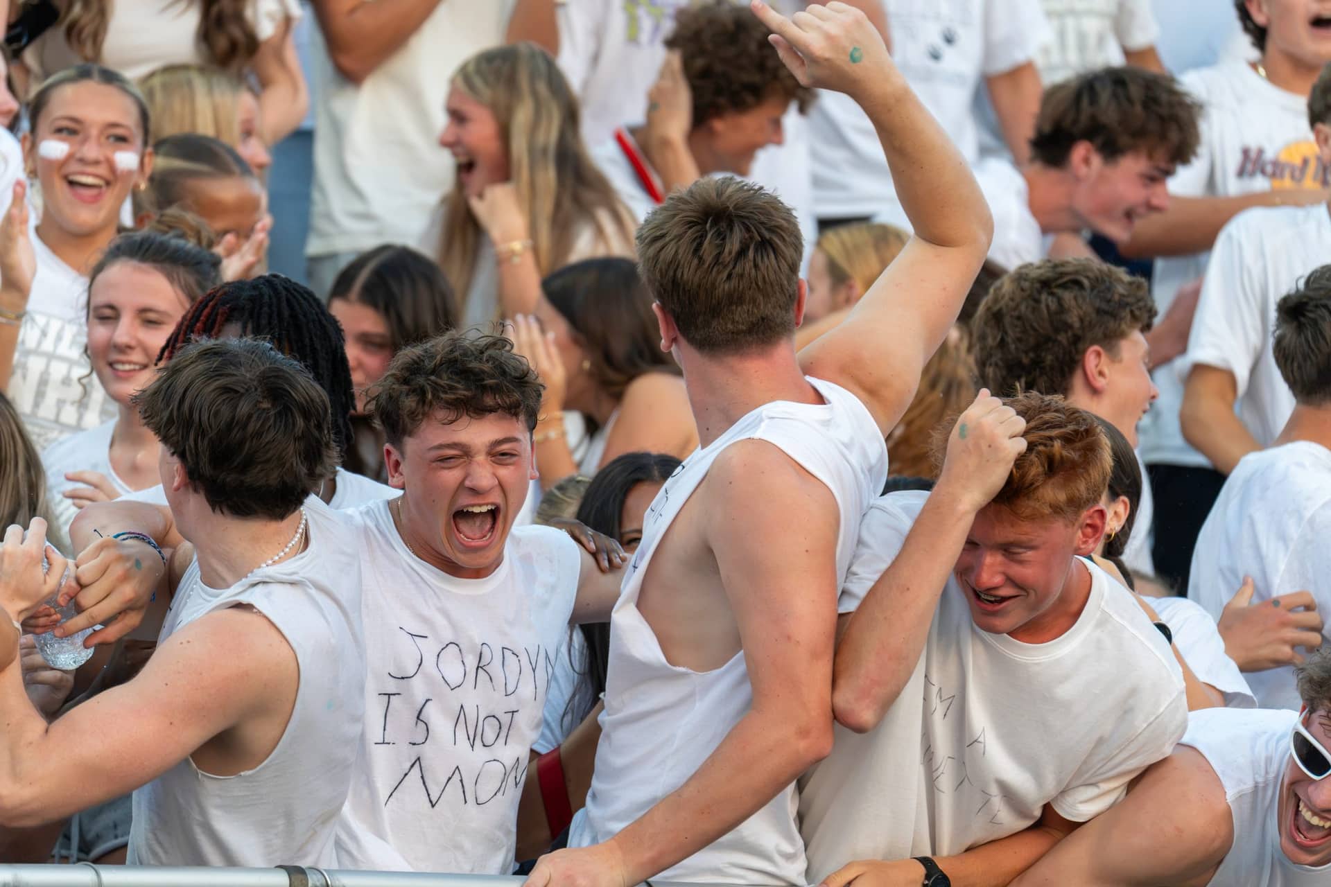 A high school student section celebrating in a whiteout