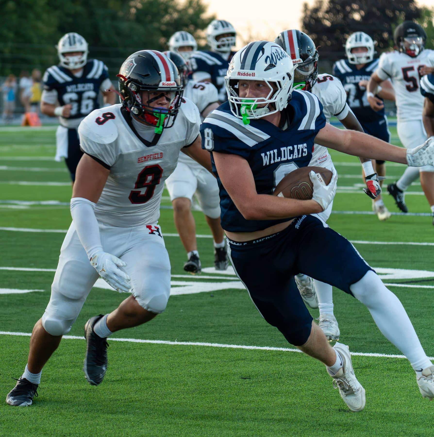 A high school running back breaking a tackle in the open field