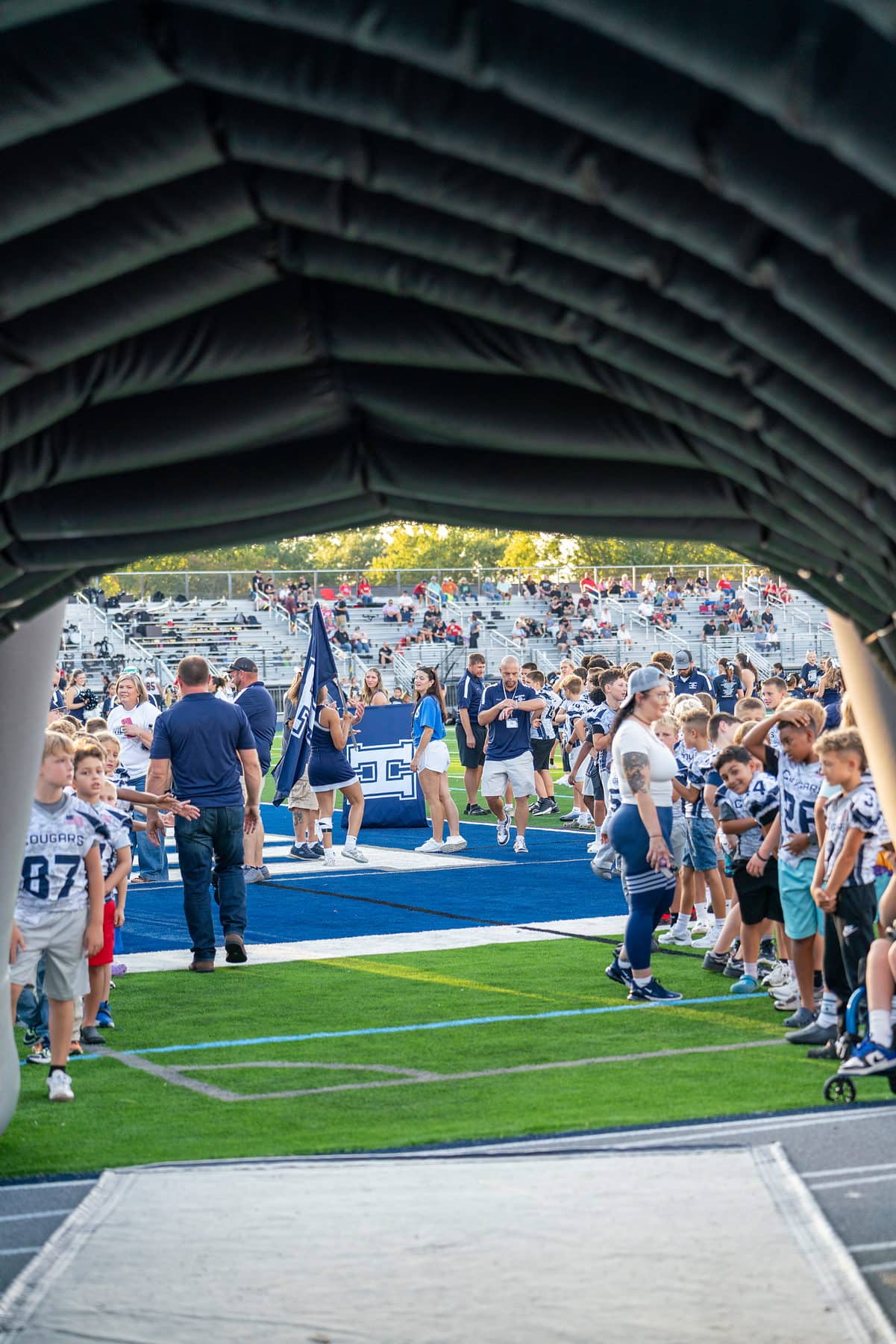 A high school football team walking out through the tunnel before kickoff