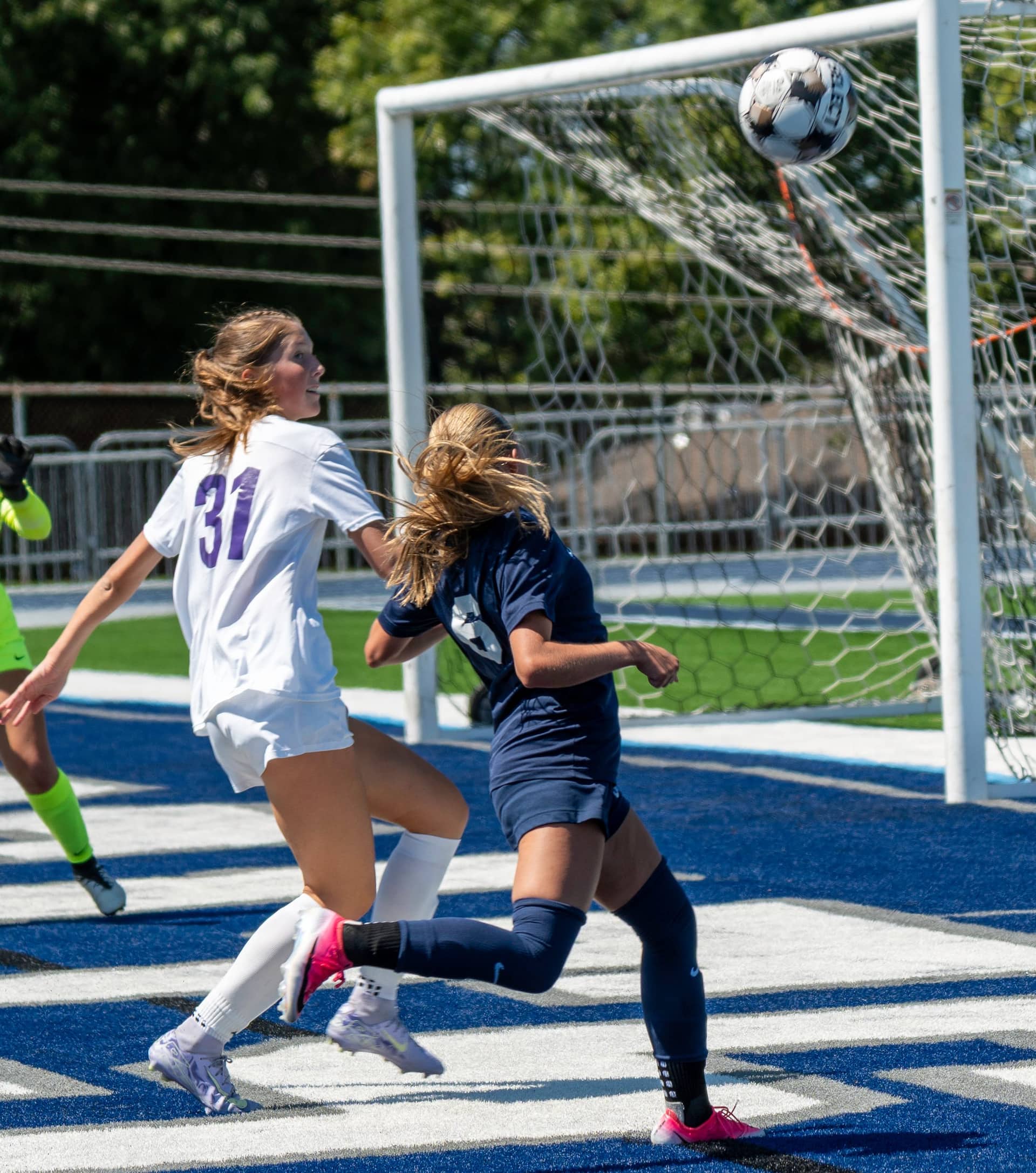 A soccer player heading the ball toward goal