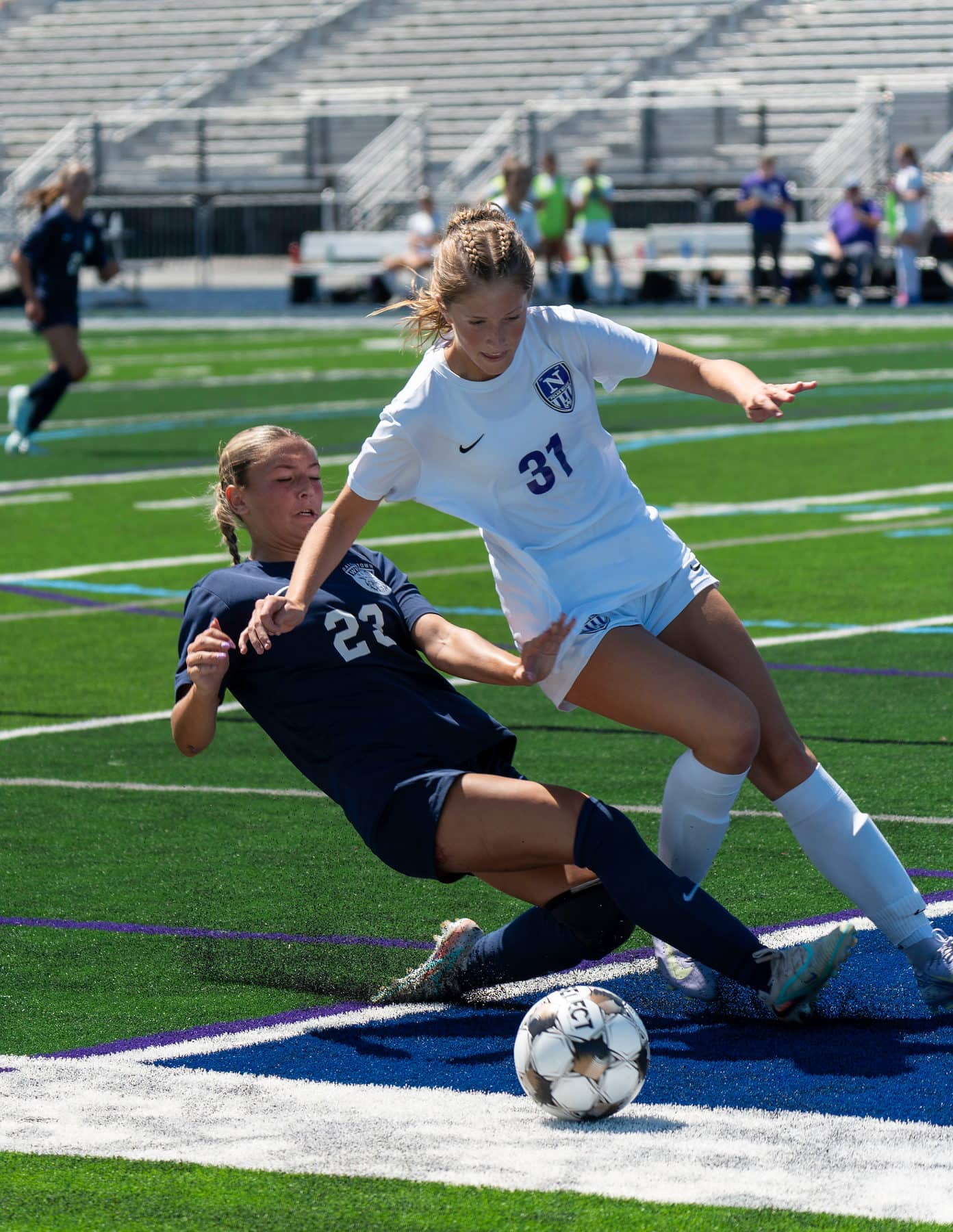A high school soccer defender committing to a slide tackle