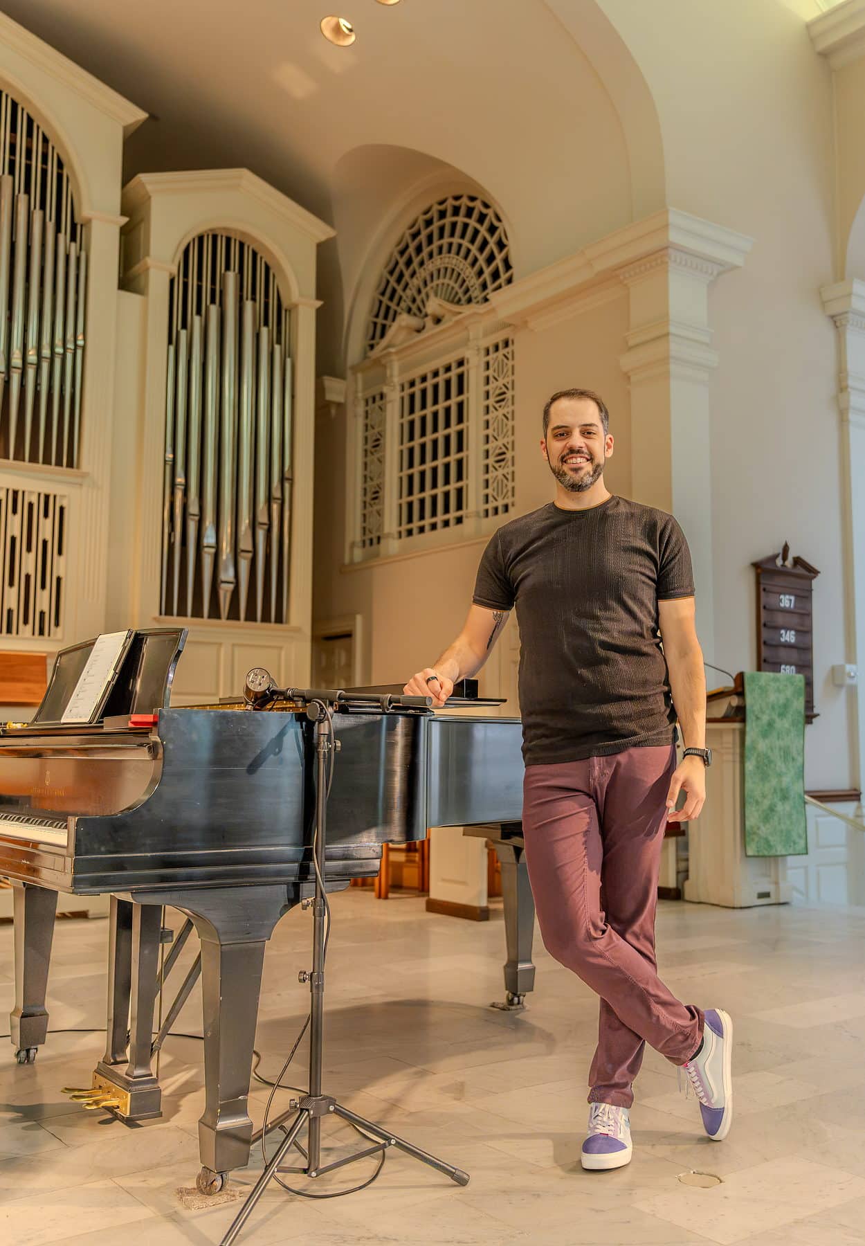 A performer leaning on the grand piano during a quiet passage