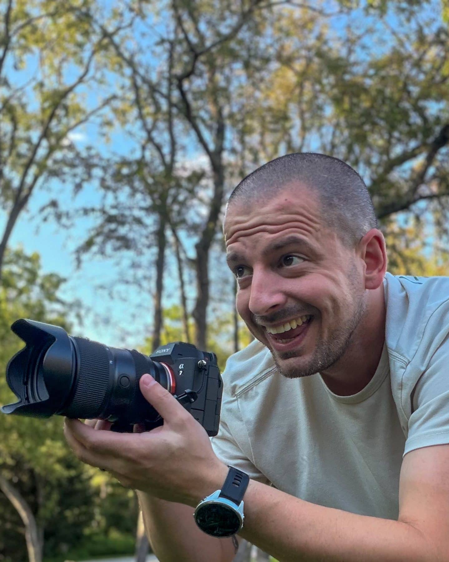 Jesse Snyder laughing, camera in hand, on a trail